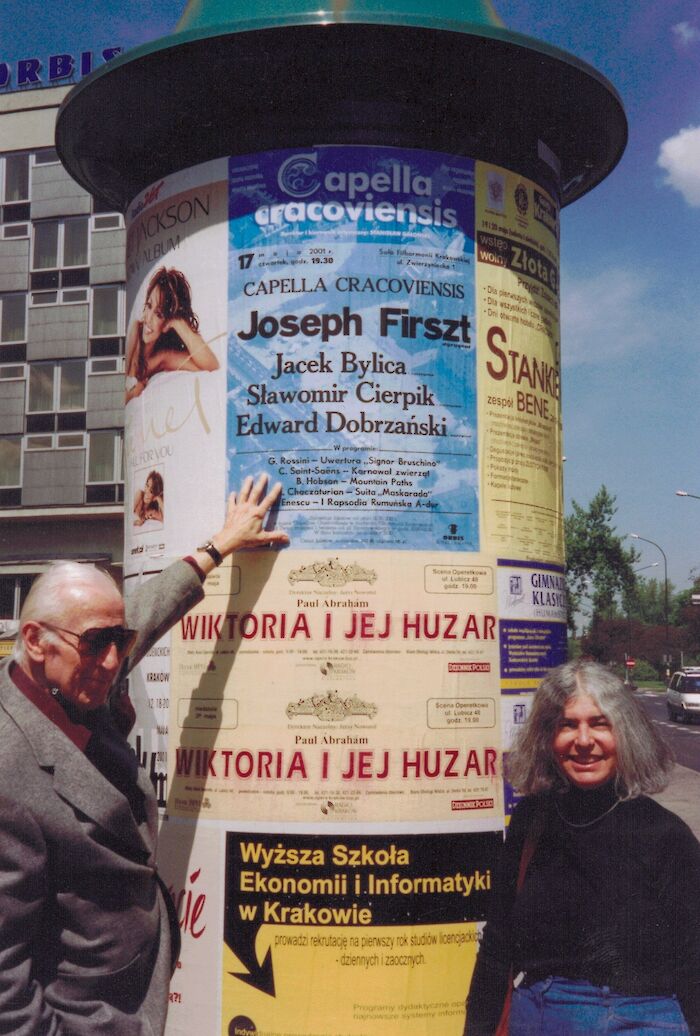 Joseph Firszt, conductor (left) with Lynda Hobson at a poster kiosk in Cracow